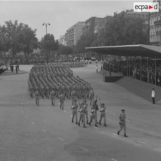 Défilé à pied. Passage du drapeau et sa garde du 120e régiment du train (120e RT) de Linas-Montlhéry devant la tribune présidentielle lors de la cérémonie du 14 juillet 1974 sur la place de la Bastille.