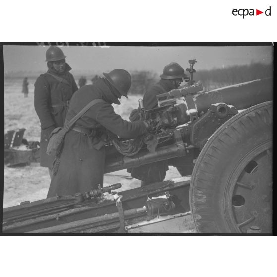 Plan moyen d'artilleurs qui approvisionnent un canon de 105 mm long modèle 1936 Schneider.