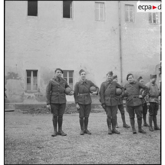 Photographie de groupe de soldats alignés face à l'objectif un ballon sous le bras.