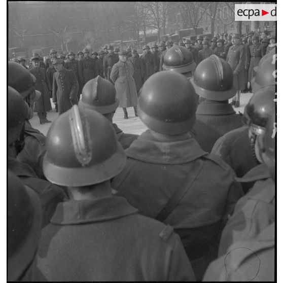 Le général d'armée Réquin s'adresse à des soldats qui l'entourent.