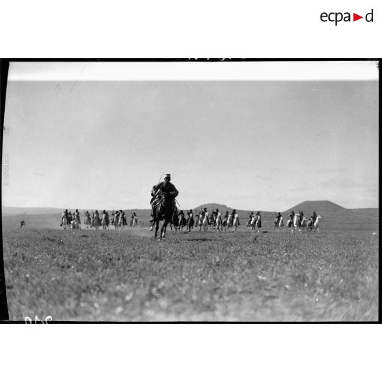 Lors d'un exercice un escadron druze charge au galop vers l'objectif au milieu d'une vaste étendue herbeuse.