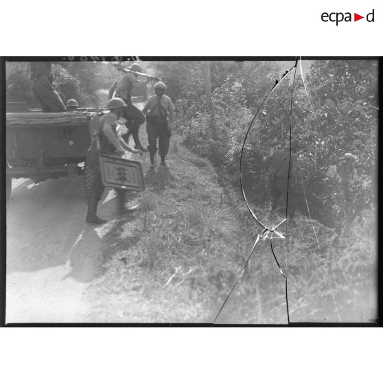 Des soldats débarquent d'un véhicule avec sur le dos les différents éléments d'un mortier de 81 mm.