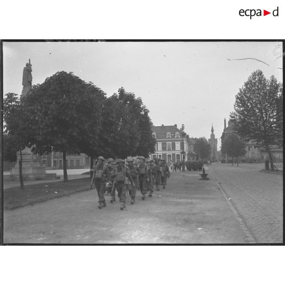 Une colonne de soldats de la BEF marche dans une rue de Béthune.