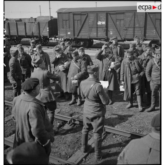 Photographie de groupe de soldats près d'une voie ferrée en gare de Trappes.