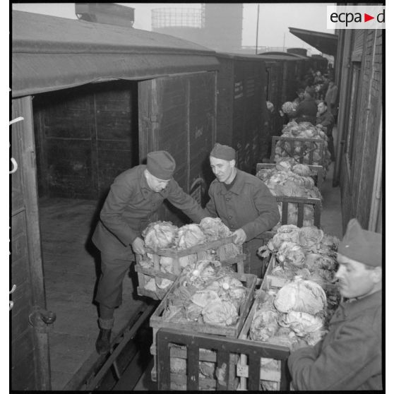 Des soldats chargent des chariots de pains dans des wagons.