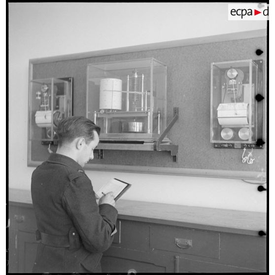 Un personnel de l'armée de l'air relève des données sur des appareils enregisteurs météorologiques.