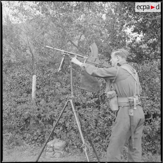 Debout un soldat des Royal Welsh fusiliers sert un fusil-mitrailleur Bren sur un affût antiaérien.