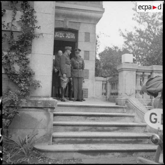 Des officiers britanniques de la BEF se tiennent à l'entrée d'une maison.