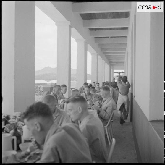 Des prisonniers libérés par le Vietminh prennent leurs repas dans les galeries de l'hôpital militaire Catroux au cours de leur convalescence.