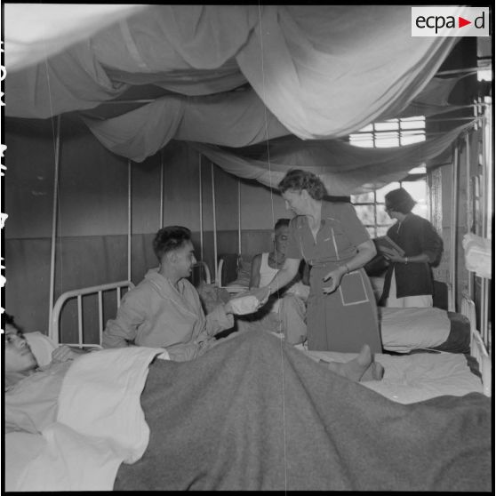 Remise de colis aux prisonniers libérés par le Vietminh par des personnels de la Croix-Rouge française à l'hôpital Catroux de Dalat.