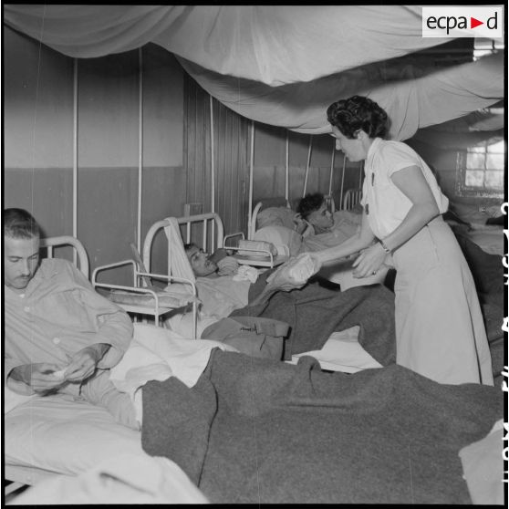 Des personnels de la Croix-Rouge française distribuent des colis aux prisonniers libérés par le Vietminh en convalescence à l'hôpital Catroux de Dalat.