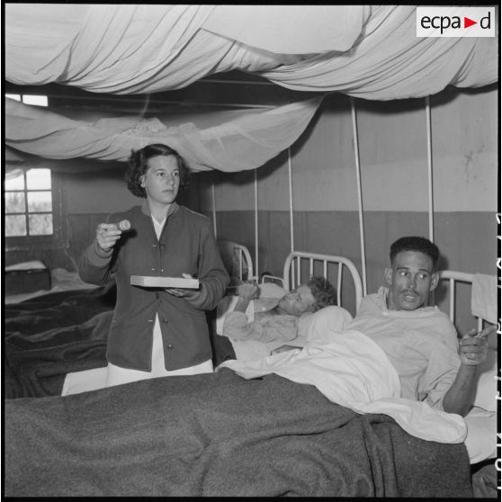 Une assistante sociale donne des soins à un tirailleur nord-africain, prisonnier libéré du Vietminh, en convalescence à l'hôpital Catroux de Dalat.