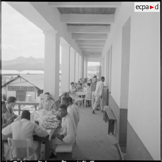 Des prisonniers libérés par le Vietminh prennent leurs repas dans les galeries de l'hôpital militaire Catroux au cours de leur convalescence.