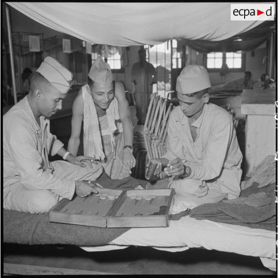 Des tirailleurs nord-africains, prisonniers libérés par le Vietminh, partagent une partie de jacquet au cours de leur convalescence à l'hôpital Catroux de Dalat.