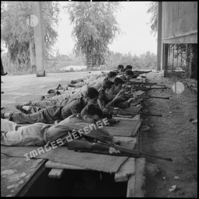 Soldats armés de fusils allongés en position de tir lors d'un pentathlon prémilitaire du service d'entraînement préparatoire et des réserves d'Alger.