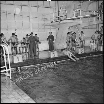 Des participants plongent dans la piscine au départ de la course.