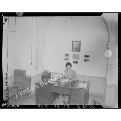 Une femme effectue des tâches administratives, assise à son bureau.