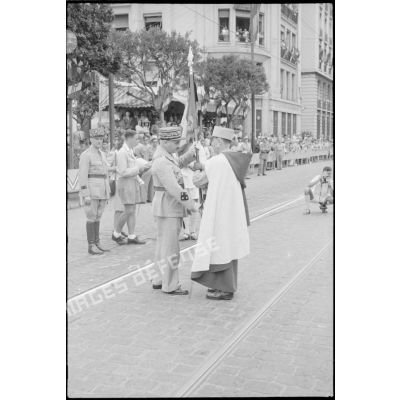 Un spahi remet un drapeau au général de corps d'armée Henry Martin, accompagné du général de division Jean Breuillac.