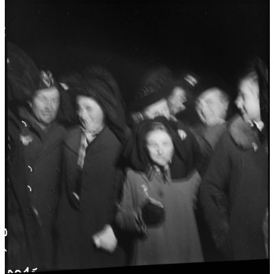 Photographie d'un groupe de jeunes Alsaciennes et de soldats sortant de la messe de Noël.
