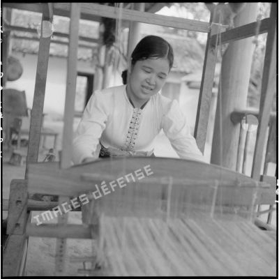 Utilisation d'un métier à tisser par une jeune femme de type Thaï blanc.