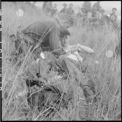 Un élément du commando 16 soigne son camarade blessé au cours d'un engagement en zone Viêt-minh.