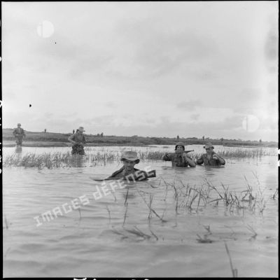 Progression des parachutistes du 6e BPC (bataillon de parachutistes coloniaux) dans les rizières inondées au cours d'une opération dans le secteur de Phuc Yen.