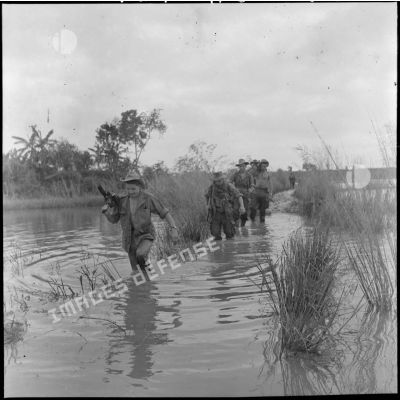 Progression de parachutistes du 6e BPC (bataillon de parachutistes coloniaux) dans les rizières inondées au cours d'une opération dans le secteur de Phuc Yen.
