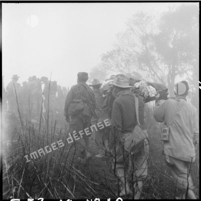 Evacuation d'un blessé transporté à dos d'hommes sur une piste accidentée, au cours d'une opération au nord de Laï Chau avec le 1er RTM (régiment de trirailleurs marocains).