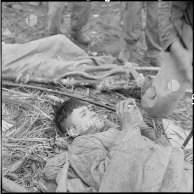 Un soldat Viêt-minh, blessé au cours d'une opération au nord de Laï Chau, attend d'être transporté.