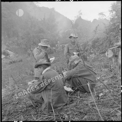Le lieutenant René Dumas et devant lui, le commandant Mirabeau, commandant le 2e Tabor, lisent le courrier qui vient d'être parachuté, au cours d'une opération au nord de Laï Chau.