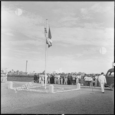 Rassemblement de PIM (prisonniers et internés militaires) dans la cour principale en face des couleurs françaises et vietnamiennes au cours d'une cérémonie pour la libération d'un groupe de prisonniers au camp de Haiduong.