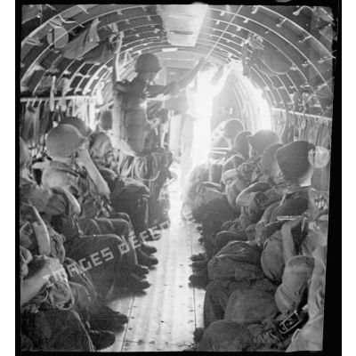 A bord d'un avion Douglas C-47, des parachutistes du 2/1 RCP (2e bataillon du 1er régiment de chasseurs parachutistes) s'apprêtent à sauter, lors d'une manoeuvre au-dessus de Tong.