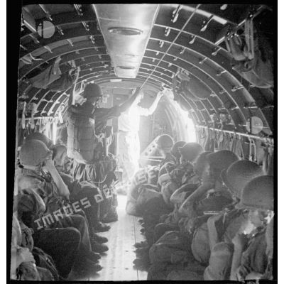 A bord d'un avion Douglas C-47, des parachutistes du 2/1 RCP (2e bataillon du 1er régiment de chasseurs parachutistes) s'apprêtent à sauter, lors d'une manoeuvre au-dessus de Tong.