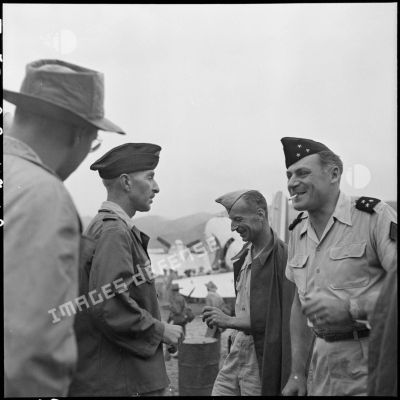 Le lieutenant-colonel Louvet, commandant le GM 7 (groupe mobile) et le lieutenant-colonel Multrier en conversation avec le général Cogny, commandant des FTVN (Forces terrestres du Nord-Vietnam), en bordure de la piste d'aviation du camp retranché de Na San, en cours d'évacuation.