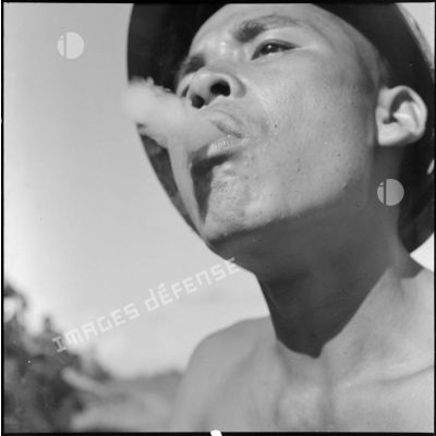 Un tirailleur vietnamien profite d'une halte pour fumer.