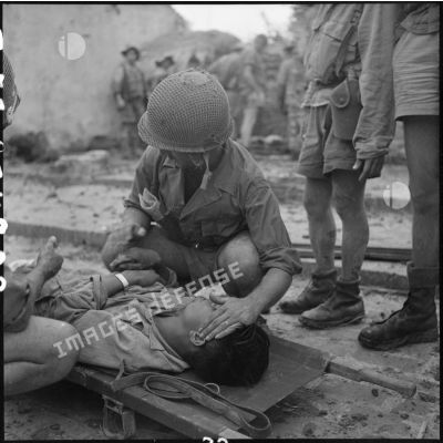 Soins médicaux apportés aux blessés, après la prise du village de My Ngo par le 3e BPVN (bataillon de parachutistes vietnamiens), au cours de l'opération Flandres.
