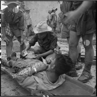 Soins médicaux apportés aux blessés, après la prise du village de My Ngo par le 3e BPVN (bataillon de parachutistes vietnamiens), au cours de l'opération Flandres.
