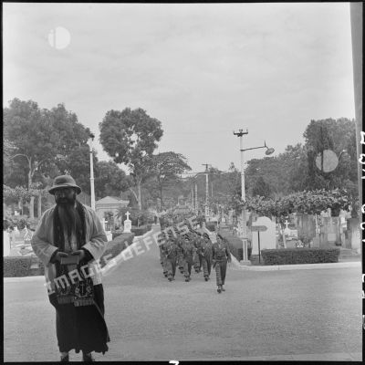 Convoi funéraire arrivant au cimetière militaire d'Hanoï lors des obsèques du médecin-capitaine Jean Raymond, en présence du prêtre et de différentes unités des TAPN (Troupes aéroportées parachutistes du Nord).
