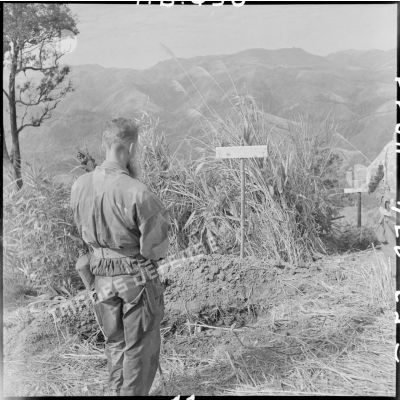 Le révérend-père Chevalier, aumônier du GAP 2 (groupement aéroporté n°2), se recueille sur la tombe des parachutistes vietnamiens.