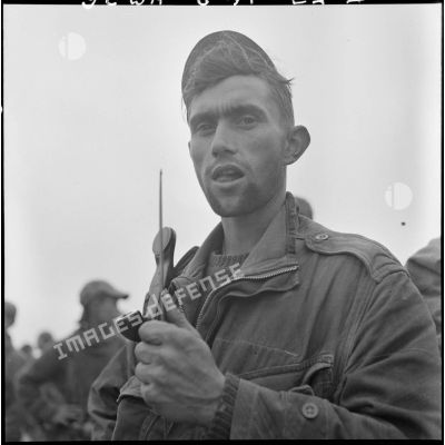 Portrait d'un parachutiste de la colonne Langlais équipé d'un combiné radio.