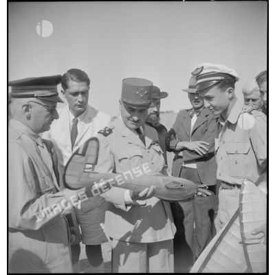 Le général de corps d'armée Henry Martin examine un modèle réduit d'avion.
