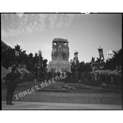 Plan en contre-plongée d'une cérémonie militaire devant le monument aux morts d'Alger.