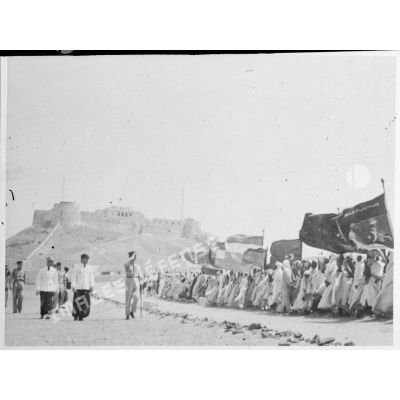 Le général Philippe Leclerc en visite à Sebha, au Fezzan, accompagné d'autorités militaires, est accueilli par la population locale.