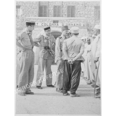 Le général Philippe Leclerc, accompagné du général Jacques Branet et du général Dubois, s'entretient avec des personnalités locales, devant le fort Colonna d'Ornano, à Mourzouk.