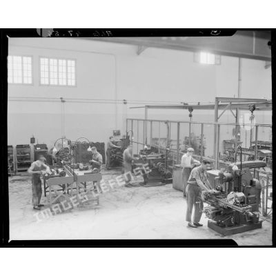 Plan en plongée d'un atelier de mécanique automobile, à l'intérieur des usines Berliet, à Alger.