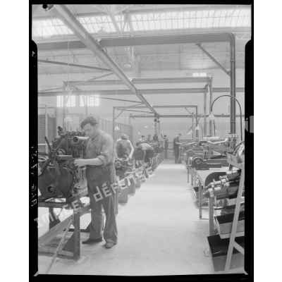 Des ouvriers de montage en construction automobile assemblent des pièces et composants, dans un atelier des usines Berliet, à Alger.