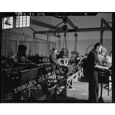 Des ouvriers de montage en construction automobile assemblent des pièces et composants, dans un atelier des usines Berliet, à Alger.