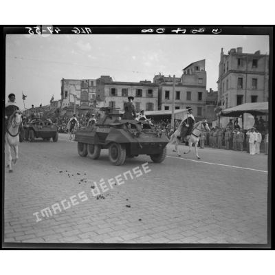 Le général Schlesser défile à bord d'un véhicule blindé, sous le regard d'autorités militaires.
