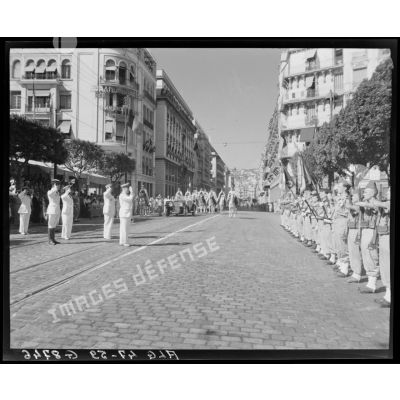 Des autorités militaires, parmi lesquelles le général Schlesser, saluent une unité militaire, à l'occasion d'un défilé, à Alger.