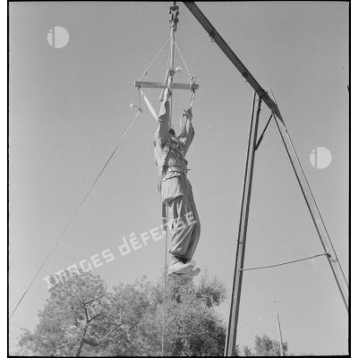 Un soldat de la 25e division alpine (DA) s'entraine au saut en parachute à l'aide d'une structure en bois.